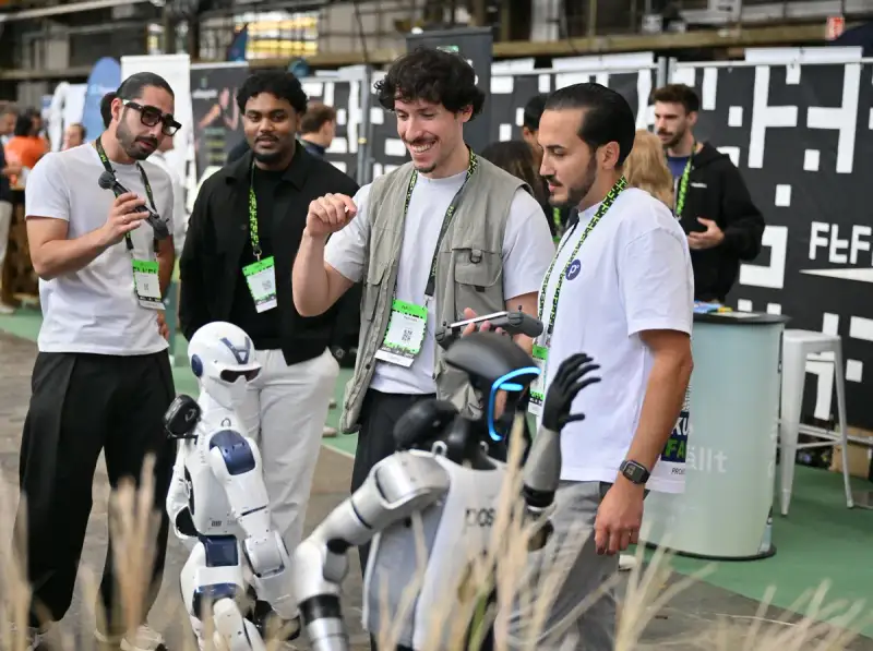 Een operator van Posevo stuurt de robots, bezoekers van Future Tech Fest Düsseldorf kijken en reageren.