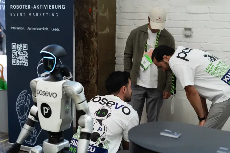 Drie mensen van Posevo maken een humanoïde robot klaar voor een inzet op een beurs.