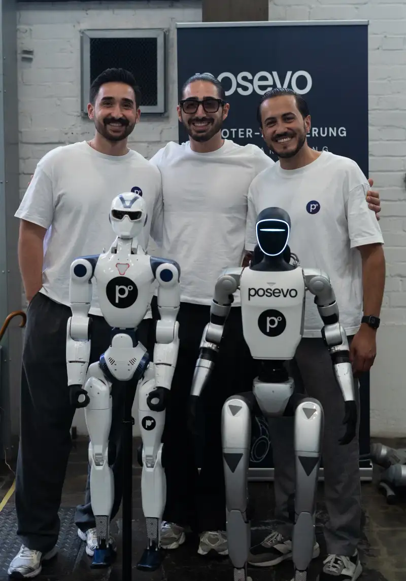 Het kernteam van Posevo met twee humanoïde robots voor een Posevo-banner.